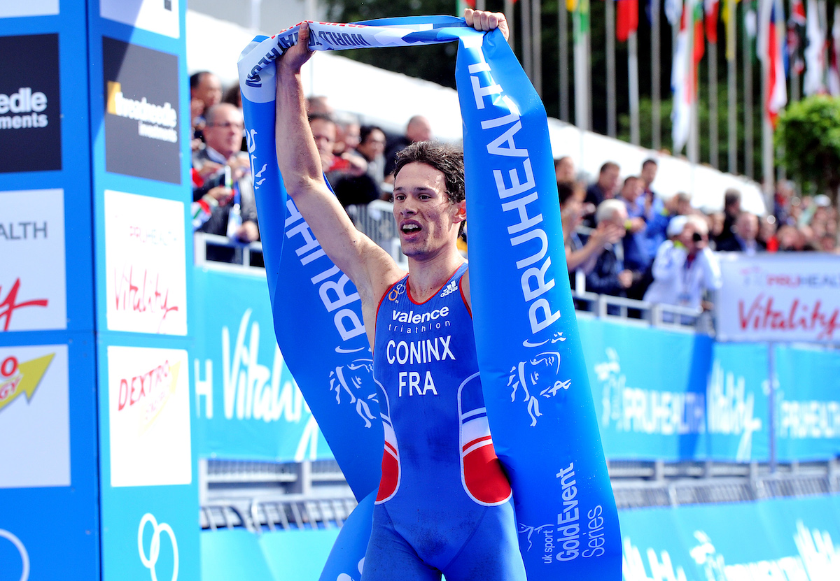 dorian-coninx-london-world-junior-champs-2013 Frenchman Dorian Coninx lifts the winner's tape above his head as he celebrates becoming the 2013 world junior triathlon champion
