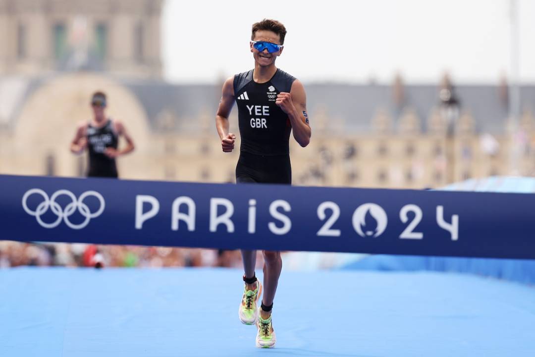 Alex Yee of Team Great Britain crosses the finish line to win gold during Men's Individual Triathlon on day five of the Olympic Games Paris 2024 at Pont Alexandre III on July 31, 2024 in Paris, France
