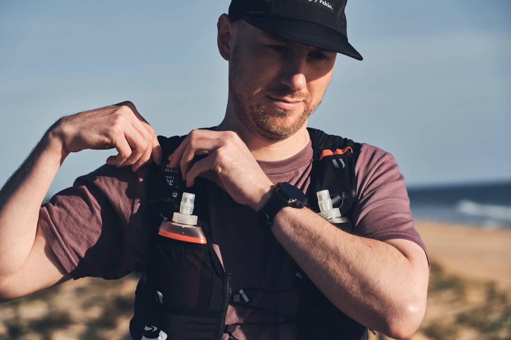 man adjusting pockets of running vest