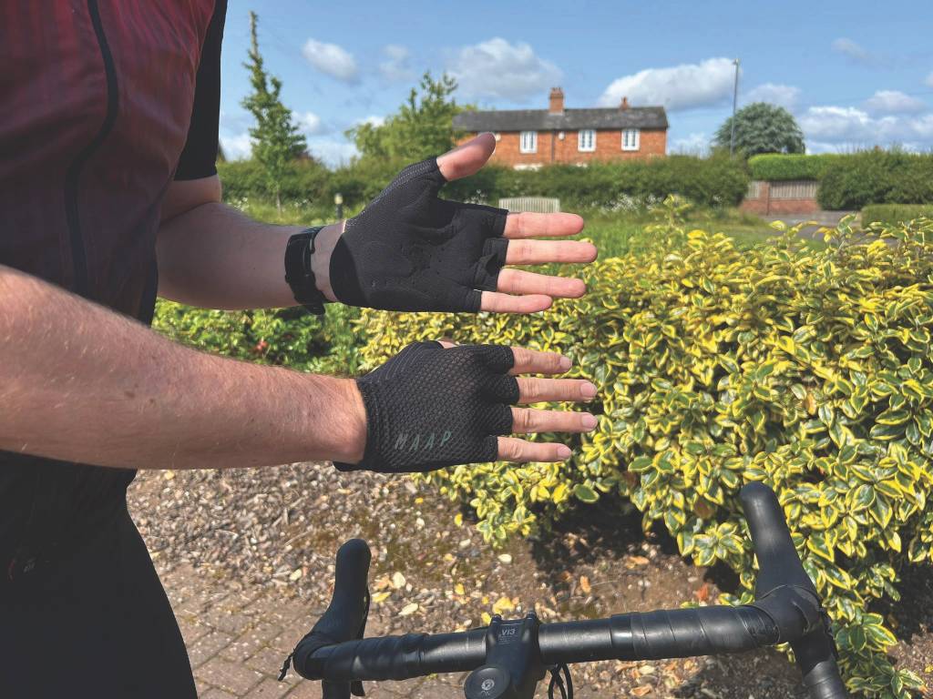 Hands of cyclists in black mitts above handlebars of bike