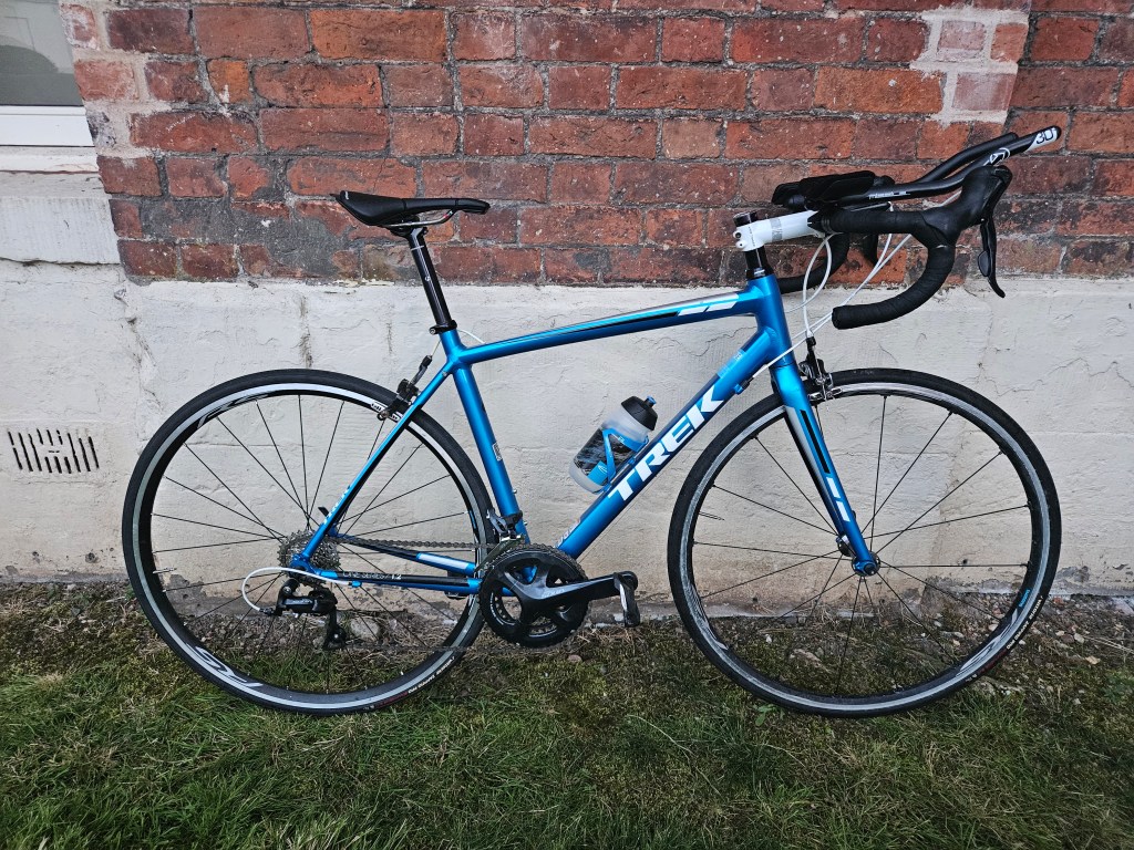 Blue road bike with aerobars clipped on to handlebars