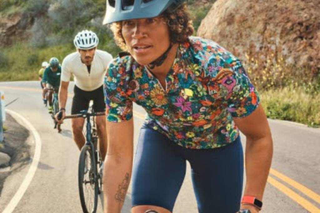 Woman cycling wearing red Fitbit Charge 6