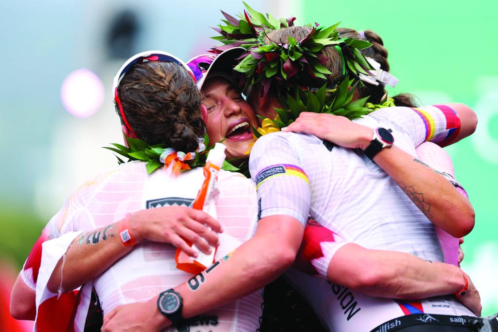 KAILUA KONA, HAWAII - OCTOBER 11: Lisa Perterer #20 of Austria is embraced by Kat Matthews #2 of the United Kingdom, Solveig Lovseth #16 of Norway and Laura Philipp #1 of Germany after completing the 2025 IRONMAN World Championship Women's Race on October 11, 2025 in Kailua Kona, Hawaii. (Photo by Sean M. Haffey/Getty Images for IRONMAN)