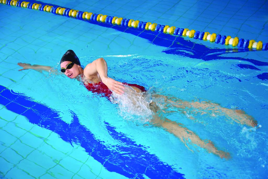 Swimmer demonstrating front crawl style during photo shoot in water