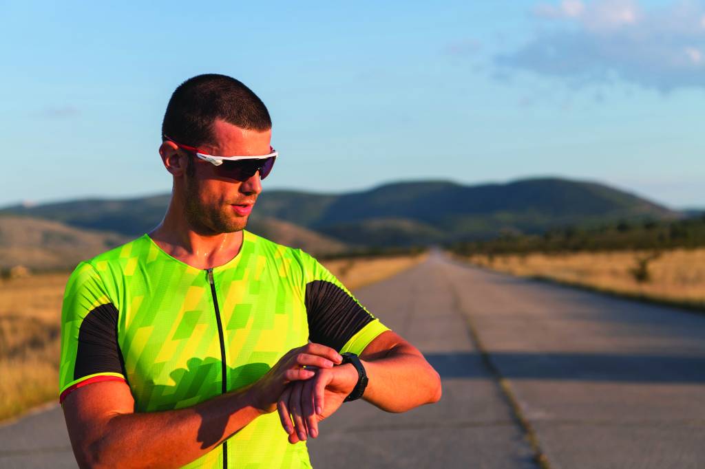 The triathlete checking his training statistics on a smartwatch, analyzing his performance and progress. With dedication, discipline, and perseverance, he strives to improve his physical abilities and achieve his goals
