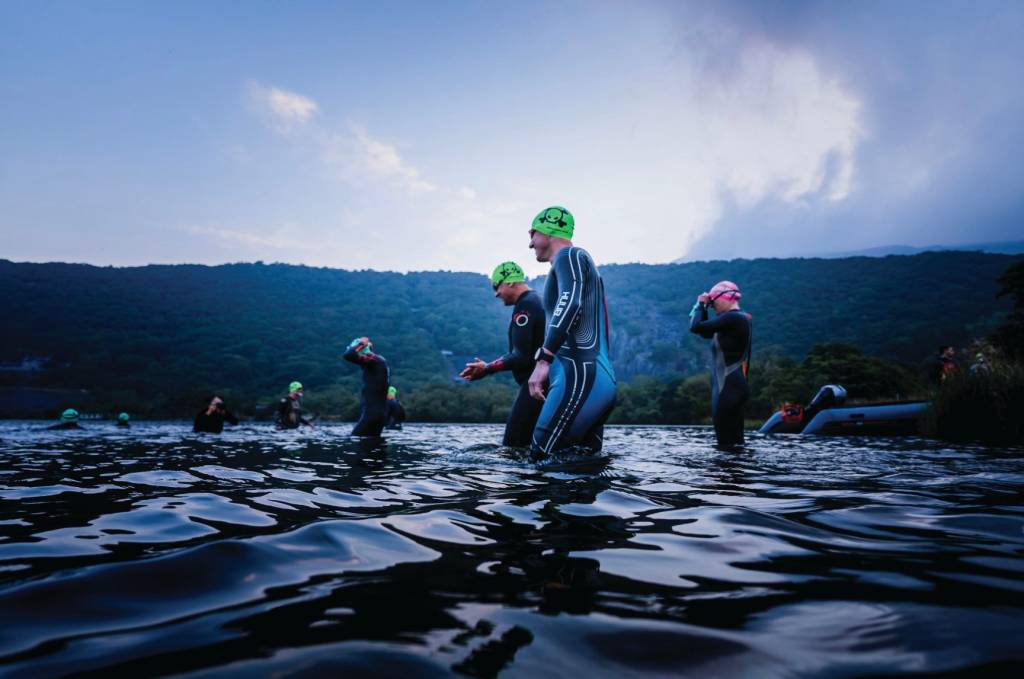 Triathletes wading through water