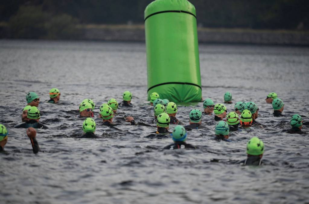 crowd of triathletes swimming round a bouy