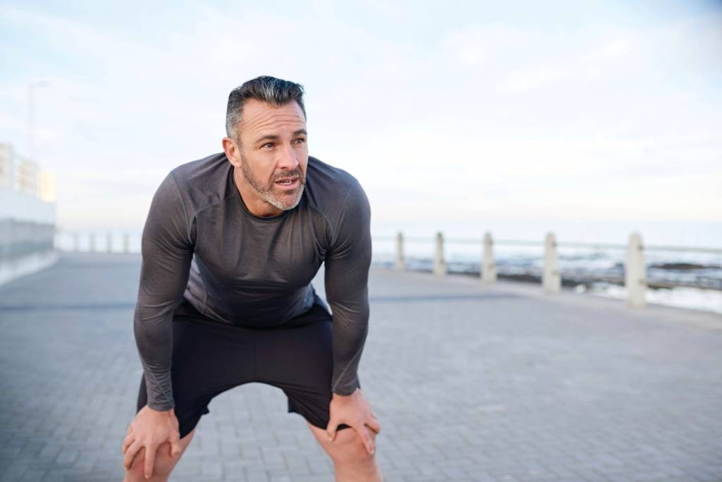 A man on his haunches recovering after a run