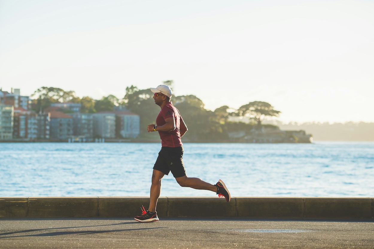 Man running on a road by the sea