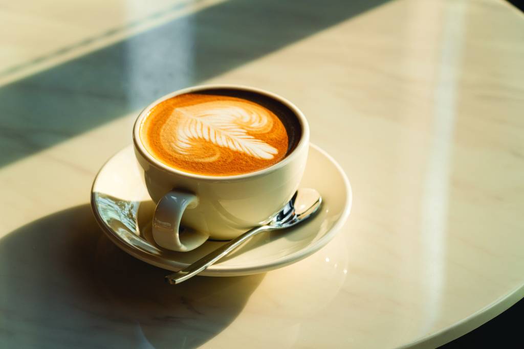 Feshly brewed  latte coffee on a white table, a coffee drink made with 