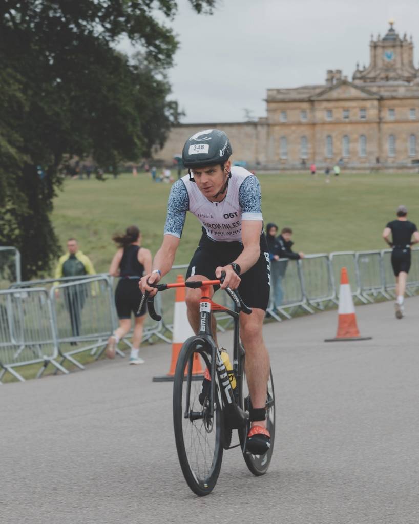 Triathlete Jonny Brownlee riding through the grounds of Blenheim Palace